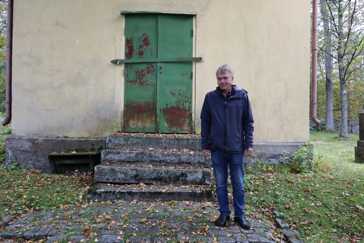 Keijo Olmari seisoo Ivan Lisitsinin ja hänen perheensä muistorakennuksen edessä
