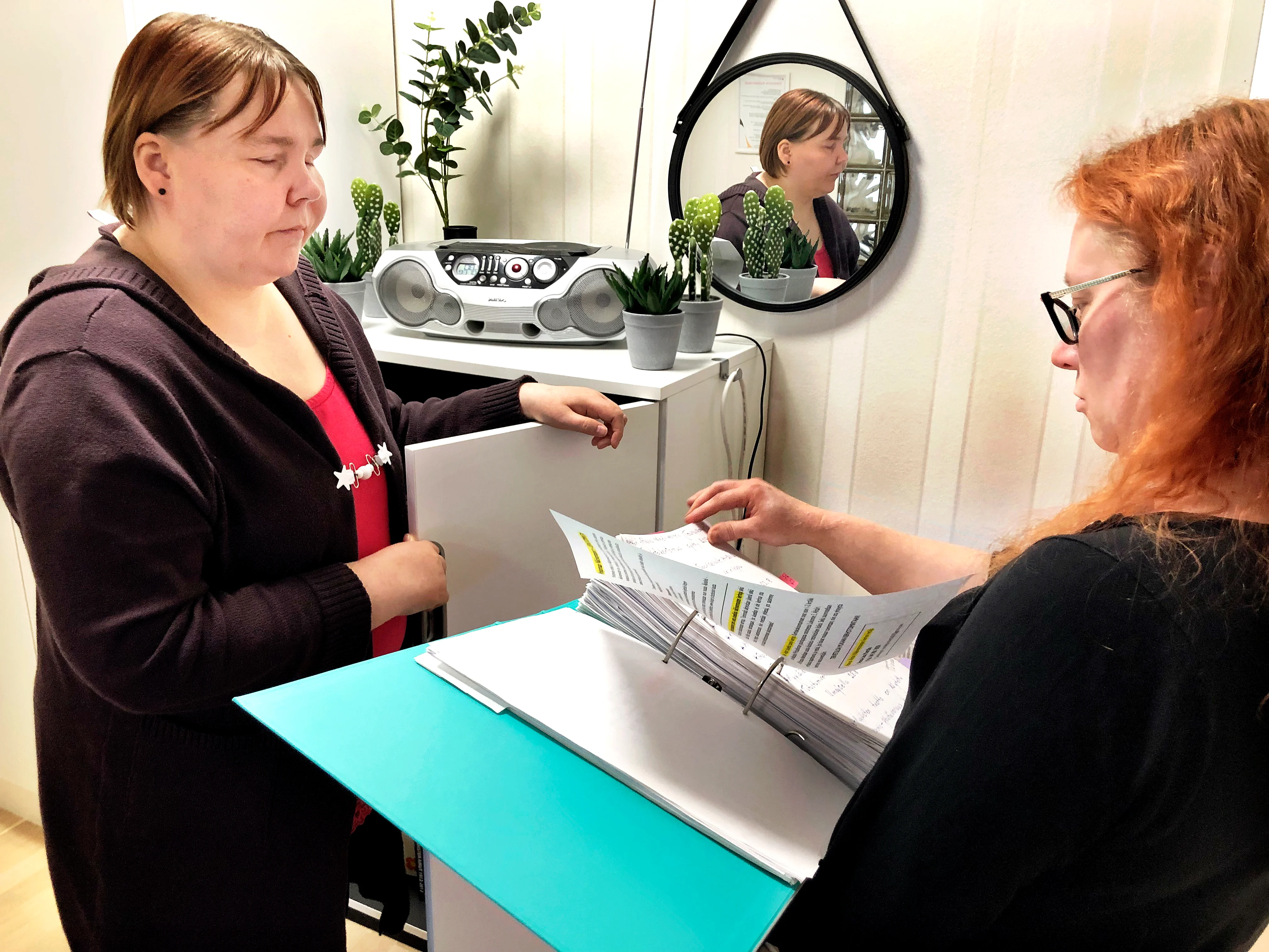 Yksi sokealle haasteita aiheuttava toimistotyö on arkistomappien selaaminen varsinkin silloin, kun ei ole itse ollut mappeja täyttämässä. Mervi Räsästä (vas.) työssä auttaa avustaja Suvi Leppälä.