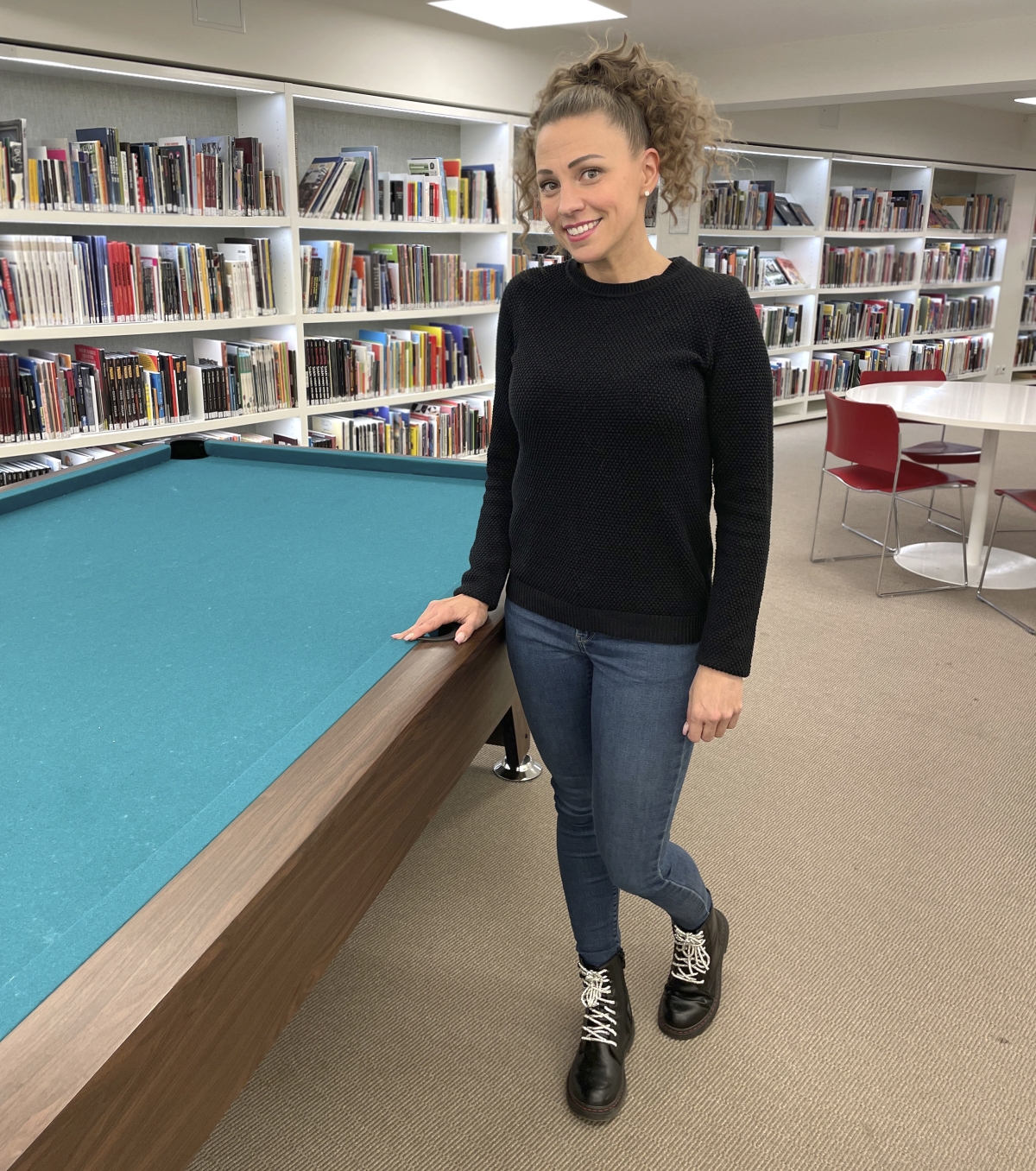 Nuoriso-ohjaaja Katja Luoma esittelee Liiverin rahoituksen avulla kirjastolle hankittua biljardipöytää.