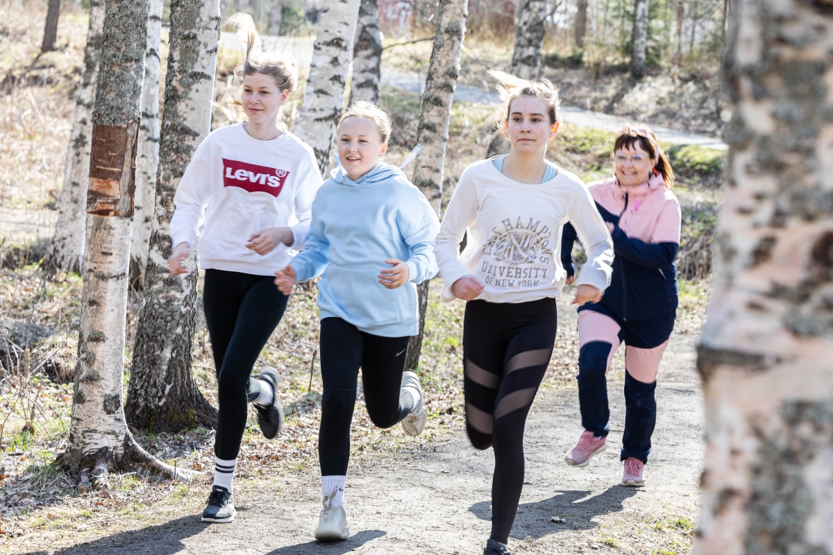 Josefina Lehtola, Aada Glasberg ja Olivia Saukko keräävät maratonpisteitä opettaja Marita Reinikan kannustamana.