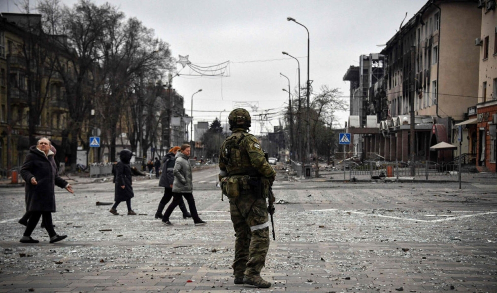 Ihmisiä kulki alkuviikosta venäläisen sotilaan ohi Mariupolissa. LEHTIKUVA / AFP