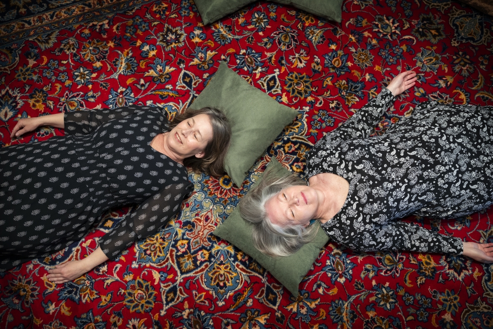 Vaasan taidehallin pientä salia hallitsee itämainen matto. Marianne Maans ja Paula Blåfield näyttävät mallia, miten matolla voi nauttia taidenäyttelystä.