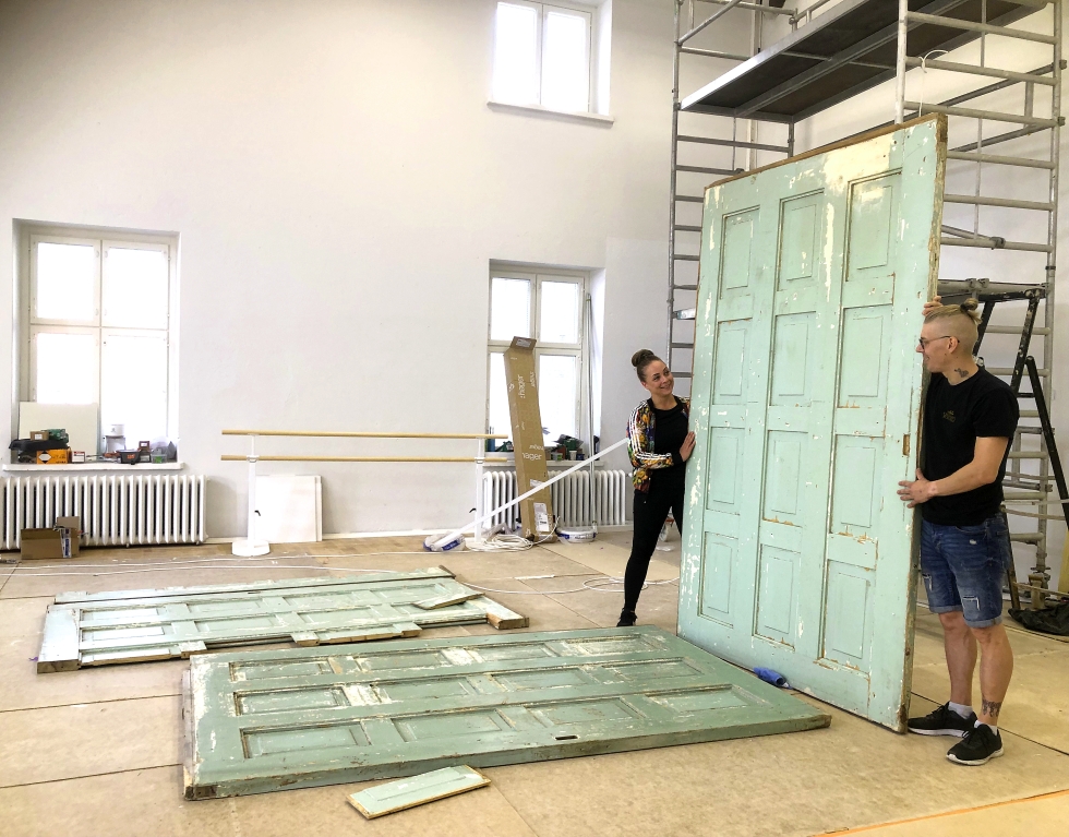 Juulia Soidinaho ja Rami Haavisto esittelemässä Piiriltä löytyneitä vanhoja ovia, joista tehdään Verstas-ravintolan liukuovet. Sisustukseen haetaan muitakin vanhoja elementtejä. 