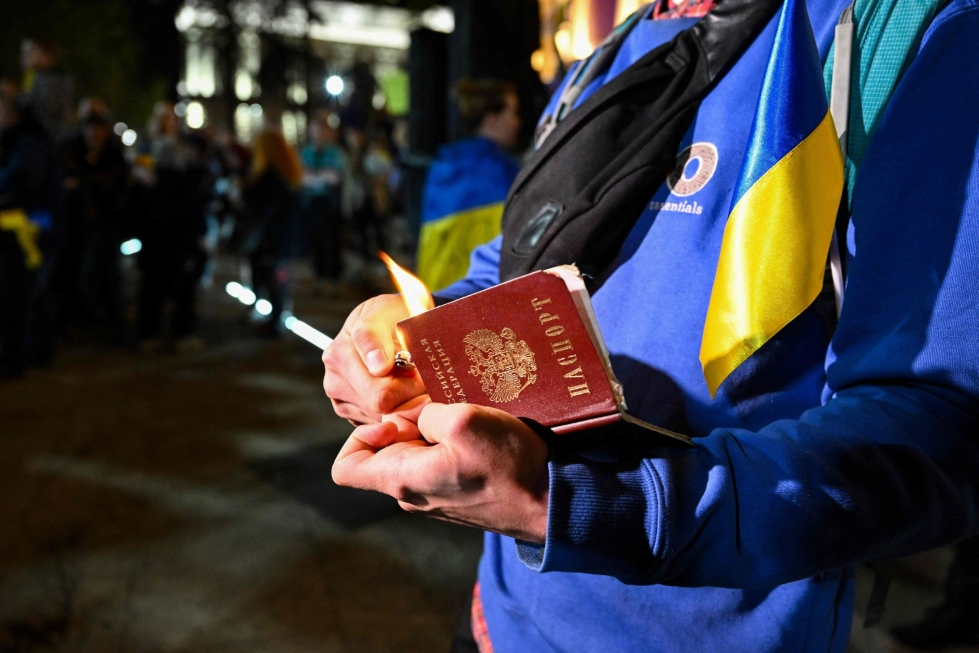 Mielenosoittaja poltti Venäjän passinsa Georgian pääkaupungissa Tbilisissa viime lokakuussa. Satojatuhansia venäläisiä poistui maastaan Venäjän hyökättyä Ukrainaan. LEHTIKUVA/AFP