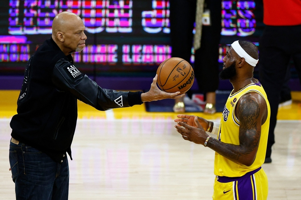 Los Angeles Lakersin LeBron James (oik) ohitti Kareem Abdul-Jabbarin (vas.) aiemman ennätyksen 38 387 pistettä ottelussa Oklahoma City Thunderia vastaan. Kuvassa Abdul-Jabbar ojentaa pallon Jamesille ennätyksen rikkoutumisen jälkeen. LEHTIKUVA/AFP