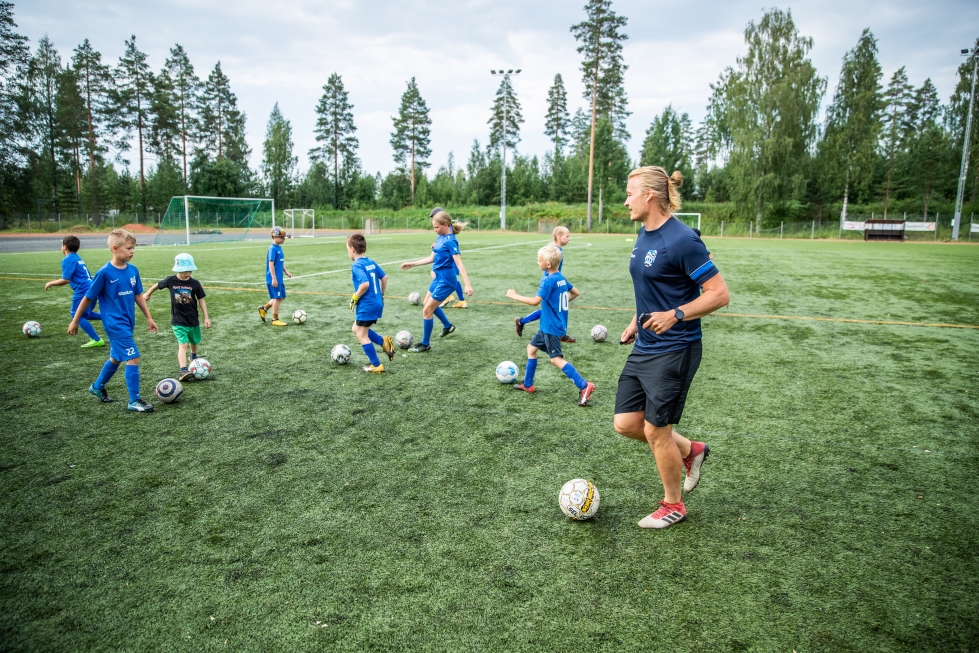 Ylämyllyn Yllätyksen valmentaja Ville Homanen opastamassa jalkapalloleiriläisiä Paloaukean tekonurmella.