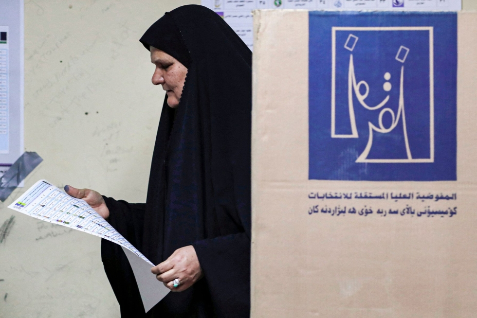 Vaalilautakunnan mukaan vaaliuurnilla kävi nyt runsaat yhdeksän miljoonaa irakilaista. Nainen tutki äänestyslippua sunnuntaina Bagdadissa. LEHTIKUVA / AFP