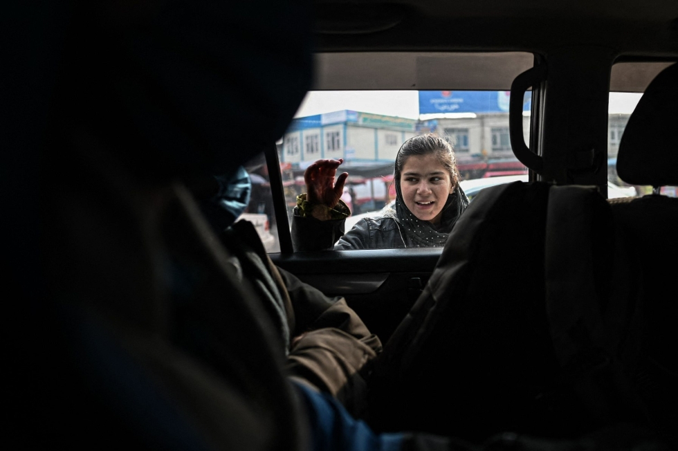 Nuori tyttö pyrki autokyytiin Kabulissa 25. joulukuuta 2021. Taleban on ohjeistanut, että kulkuneuvojen omistajien tulee tarjota kuljetusta vain naisille, jotka käyttävät hijabia. LEHTIKUVA/AFP 