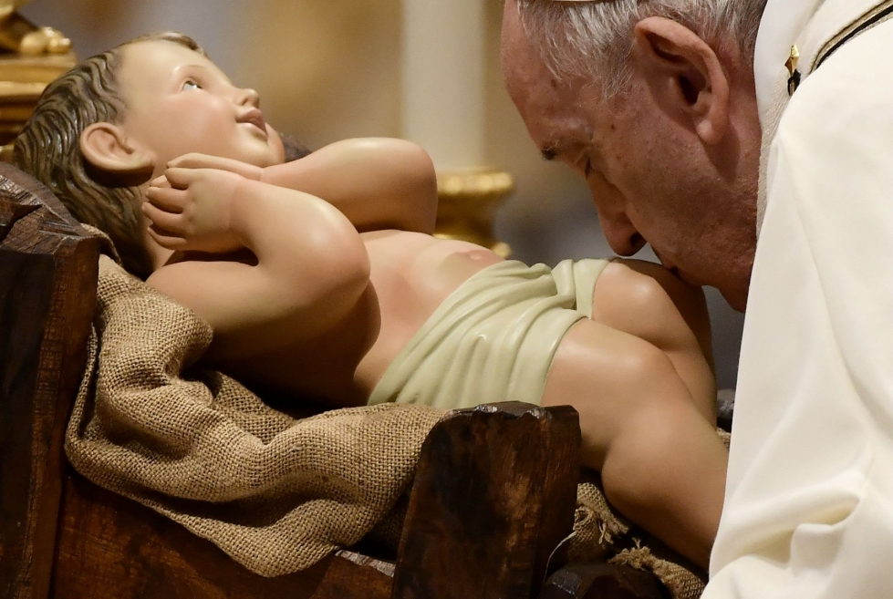 Paavi Franciscus suuteli Jeesus-lasta esittävää figuriinia jouluaaton messun aikana. LEHTIKUVA / AFP 