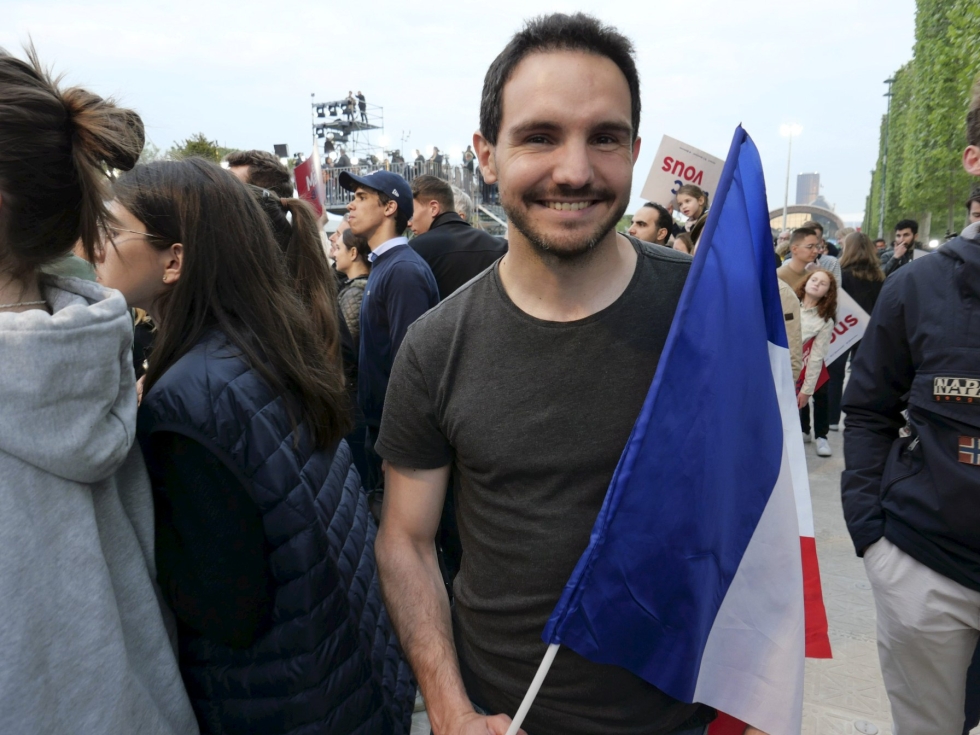 Ranskan lipun kanssa Eiffel-tornin edustalla tanssinut Marc Escudier oli silminnähden onnellinen vaalituloksesta. Lehtikuva / Heta Hassinen
