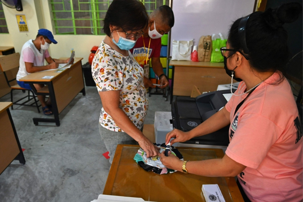 Äänestäjä kävi pudottamassa vaalilipukkeensa uurnaan Manilassa maanantaina. Lehtikuva/AFP