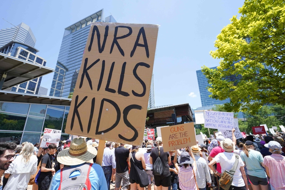 Aseita vastustavat mielenosoittajat kokoontuivat aselobbausjärjestö NRA:n konferenssipaikan ulkopuolelle Houstonissa perjantaina. NRA tappaa lapsia, kyltissä luki. LEHTIKUVA / AFP