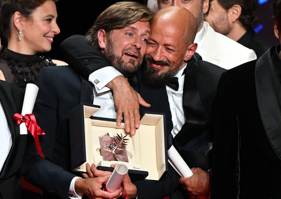 Ruotsalaisen Ruben Östlundin (keskellä) ohjaukselle osattiin odottaa menestystä elokuvajuhlilla.  LEHTIKUVA / AFP