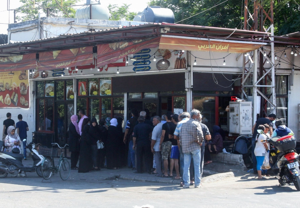 Ruuan, sähkön ja polttoaineen osto on käynyt Libanonissa monille perheille lähes mahdottomaksi. Kuvassa jonotetaan leipomoon. LEHTIKUVA/AFP