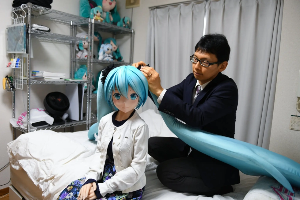 Akihiko Kondo kotonaan Tokiossa Hatsune Miku nuken kanssa, joka on virtuaalinen pop-tähti.