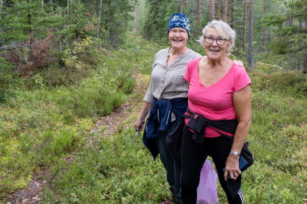 Merja Laakkonen (vas.) ja Marja Känninen tekevät matkaansa hyvällä mielellä naureskellen. Sienisaaliin saa kulkemaan mukana helposti muovipussissa.