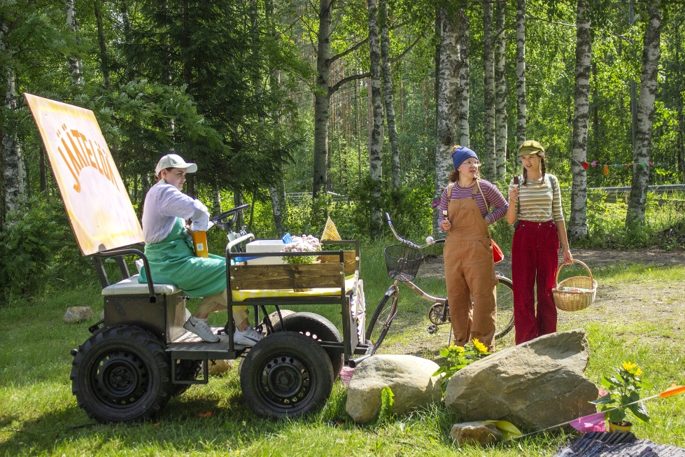 Unna Räsänen (kesk.) ja Aava Kervinen (oik.) näyttelevät Vadelmaa ja Kanelia, jotka asioivat Nina Wikströmin esittämän jäätelömyyjän luona.