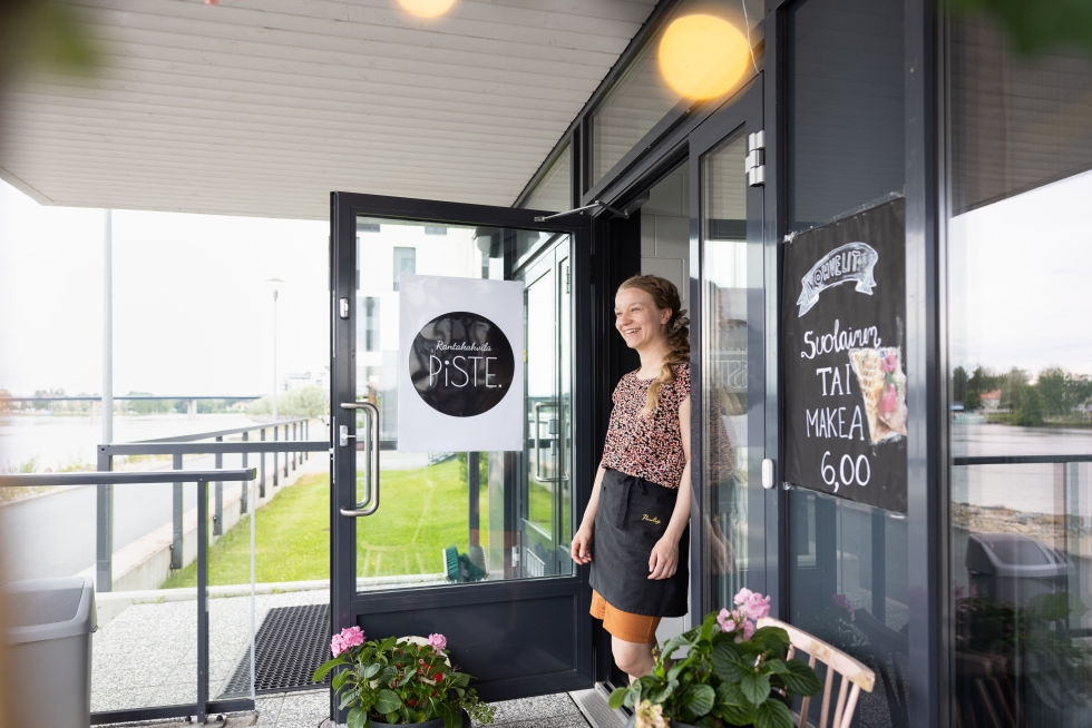 Maija Ruotsalainen pyörittää Penttilänrannassa Piste-kahvilaa toisena yrittäjänä. Alkuun kahvilan avaaminen joen itäpuolelle arvelutti, mutta jokinäkymä ja ilta-aurinko onneksi ovat vetäneet asiakkaita puoleensa.