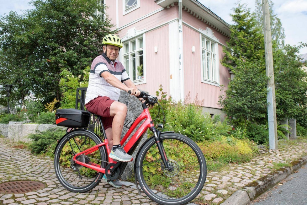 Sähköpyöräilyä harrastava Markku Karvonen on juuri tilannut aurinkopaneelit puutalonsa katolle.