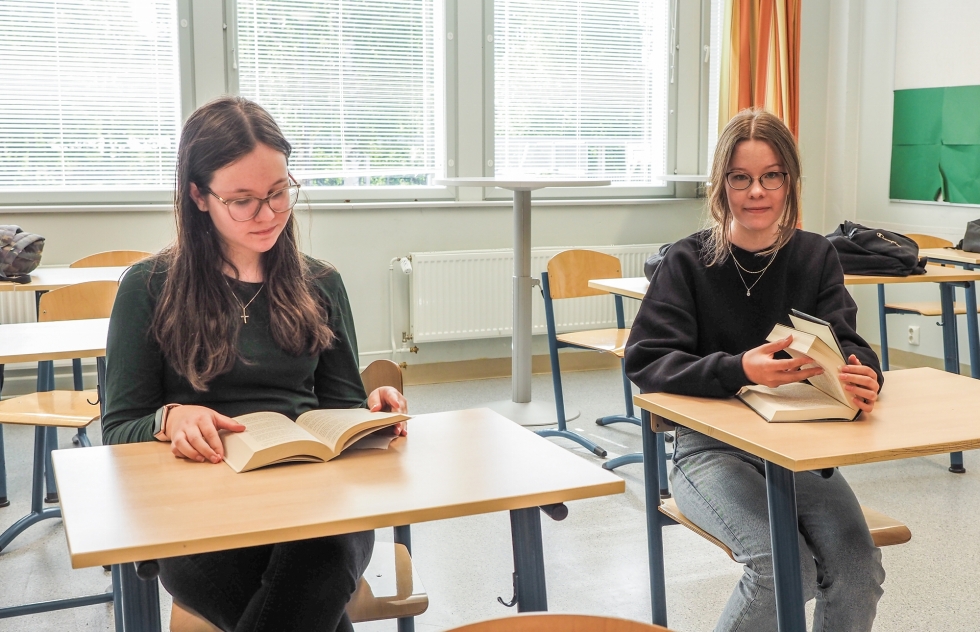Kontiolahden koulun Sanni Surakka (vas.) ja Enni Kettunen lukevat kirjoja englanniksi ja suomeksi.