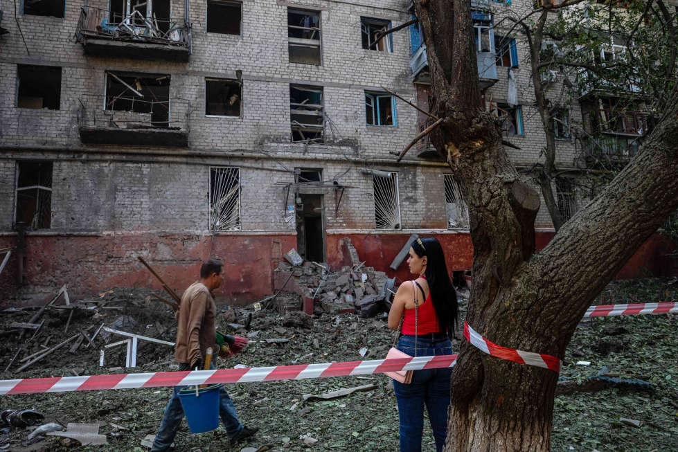 Paikallisia asukkaita ohjusiskussa vaurioituneen rakennuksen edustalla Donetskin Kramatorskissa elokuun lopulla. LEHTIKUVA/AFP