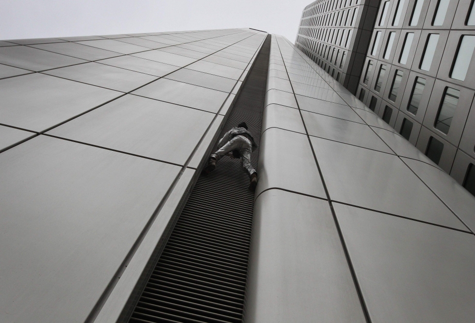 Alain Robert on kiivennyt lukuisien pilvenpiirtäjien huipulle. Vuonna 2020 hän kapusi tornitaloa pitkin Frankfurtissa. Lehtikuva/AFP