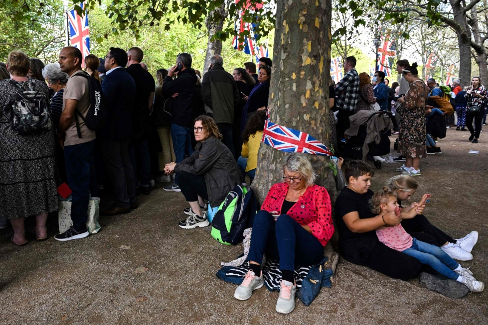 Lontoon keskustassa ihmiset odottavat näkevänsä kuningatar Elisabetin surusaattoa. LEHTIKUVA / AFP 