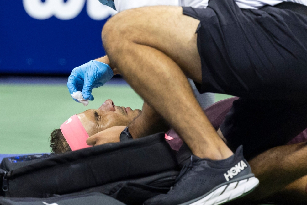 Lääkintätauon Nadal vietti makuuasennossa, kun veristä nenää paikkailtiin laastarilla. LEHTIKUVA/AFP