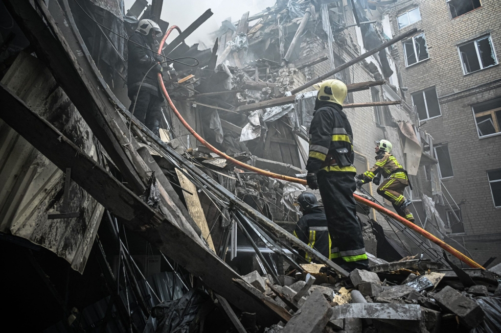 Palomiehet sammuttivat tulipaloa ohjusiskun vaurioittamassa talossa Harkovassa tiistaina. LEHTIKUVA/AFP