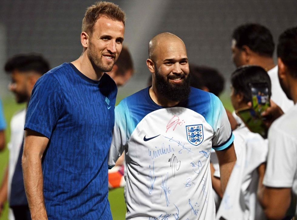 Englannin Harry Kane (vas.) otti yhteiskuvan siirtotyöläisen kanssa stadionilla Dohassa Qatarin MM-kisojen alla 17. marraskuuta. AFP/LEHTIKUVA
