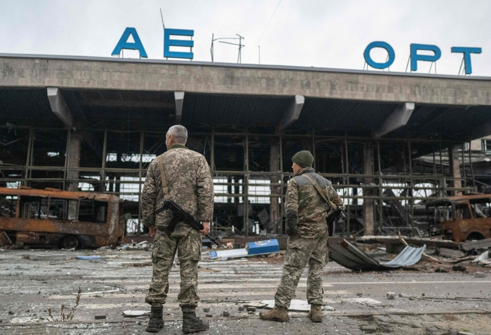 Kaksi ukrainalaista sotilasta seisoo tuhotun lentokenttärakennuksen luona Ukrainan Hersonin alueella. LEHTIKUVA / AFP