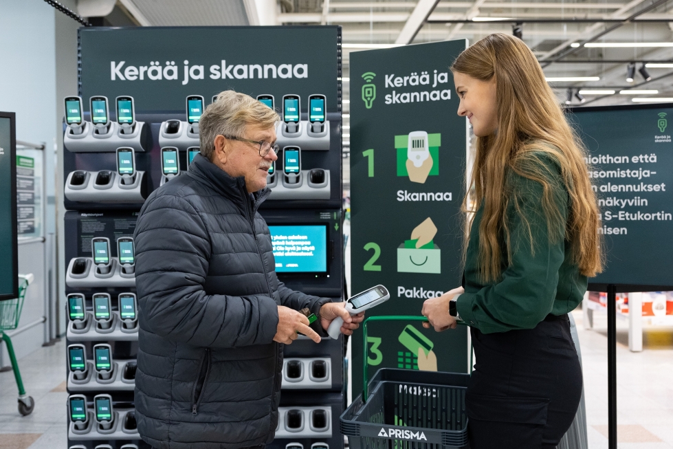 Hannu Partanen kokeili ensimmäistä kertaa tuotteiden skannausta suoraan ostoskoriin Joensuun Prismassa. Myyjä Kasia Gogola opasti.