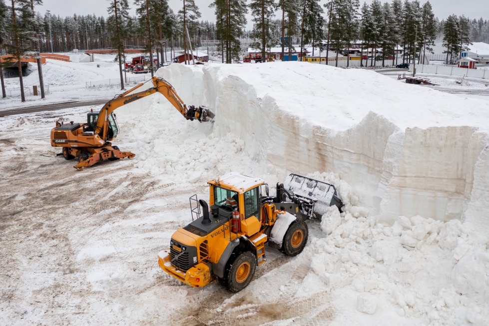 Työkoneet louhivat lunta ladulle levitettäväksi Kontiolahden ampumahiihtostadionilla keskiviikkona.