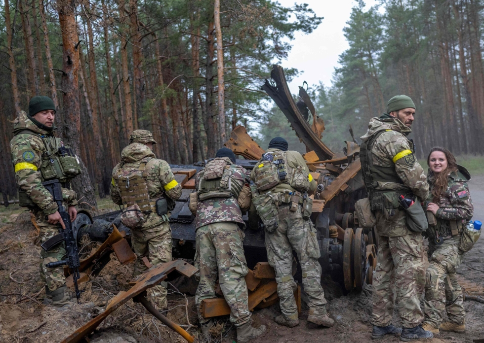 Ukrainalaiset sotilaat ja vapaaehtoistaistelijat tutkivat tuhottua Venäjän tankkia paikassa, jonka sijaintia ei kerrottu. LEHTIKUVA/AFP