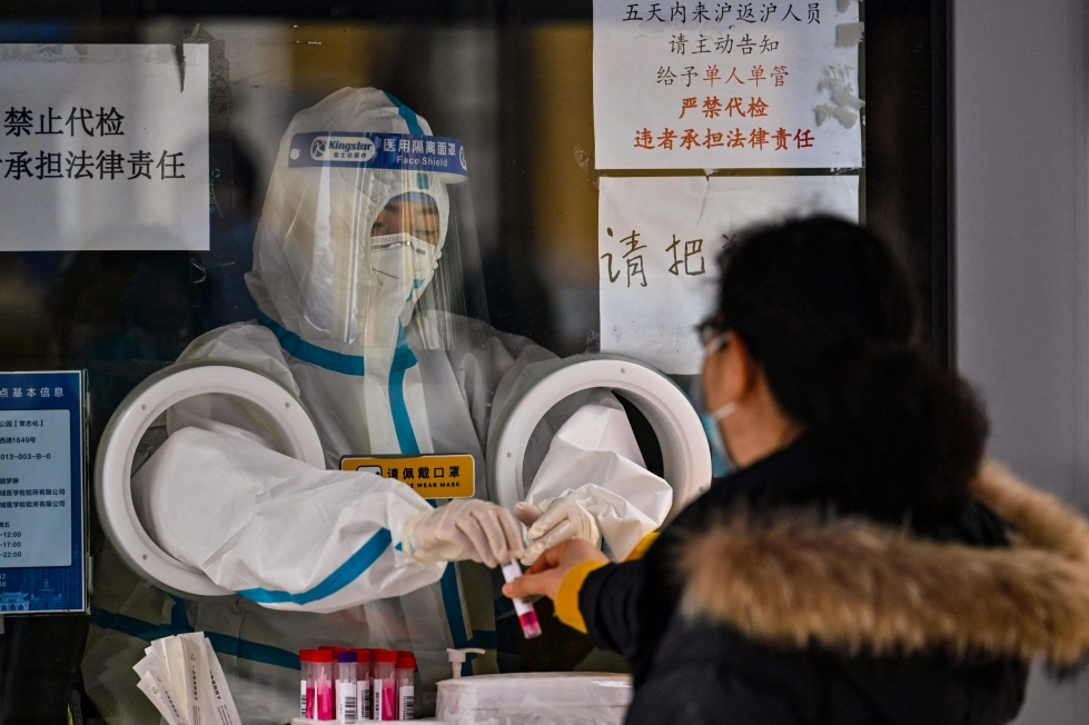 Aiemmin myös muut maat ovat asettaneet erityisiä matkustusrajoitteita Kiinasta tulijoille sen jälkeen, kun koronatartuntojen määrä Kiinassa nousi jyrkästi maan luovuttua äärimmäisen tiukoista koronarajoituksista. Kuvassa terveydenhuollon työntekijä valmistautuu ottamaan näytettä koronatestiä varten Shanghaissa 8. joulukuuta. LEHTIKUVA/AFP