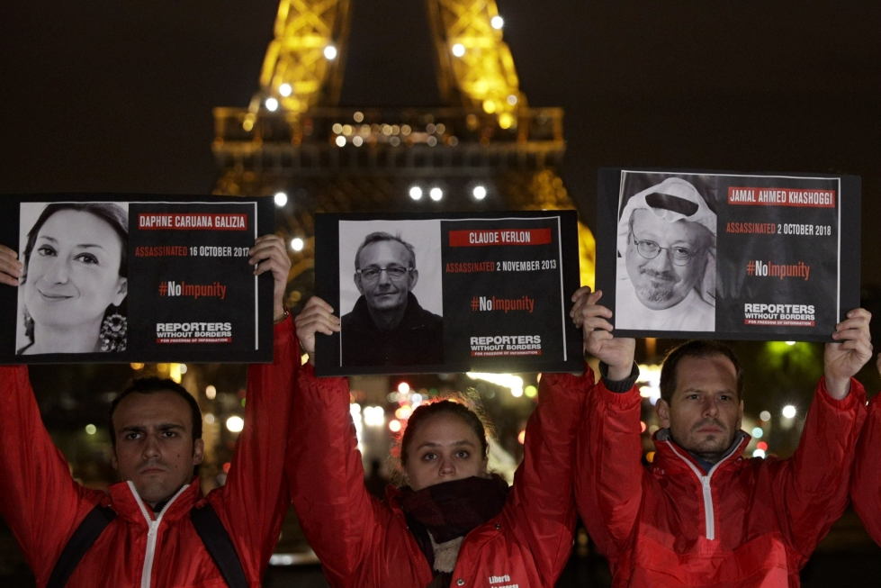 Tänä vuonna on surmattu 58 toimittajaa, kun taas viime vuonna työssään tapettiin 51 toimittajaa. Kuvassa ihmiset pitävät kylttejä surmatuista toimittajista Eiffel-tornin edessä Toimittajat ilman rajoja -järjestön tapahtumassa Pariisissa marraskuussa 2018. LEHTIKUVA/AFP