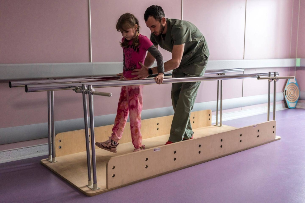 Kuusivuotiaan Maryna Ponomariovan vasen jalka jouduttiin amputoimaan polven alapuolelta pomminsirpaleiden aiheuttamien vammojen takia. Nyt hän harjoittelee uudelleen kävelemään fysioterapeutti Nazar ­Borozniukin avustuksella.