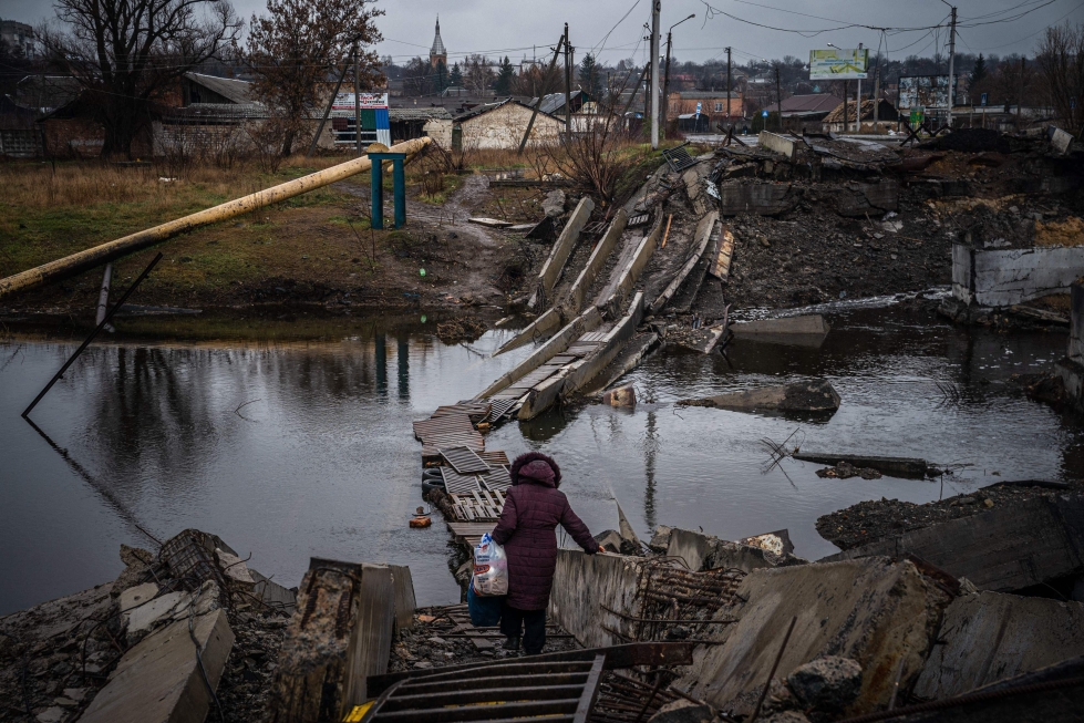 Paikallinen asukas ylitti tuhottua siltaa Bahmutissa Donetskin alueella. Suurin osa alueen asukkaista on jo lähtenyt taisteluiden jaloista.