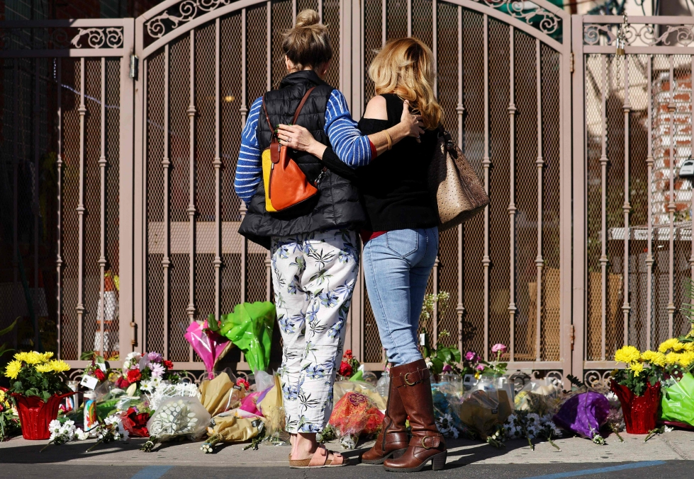 Ihmiset ovat jättäneet kukkia muistopaikalle joukkoampumisessa menehtyneille Kaliforniassa.