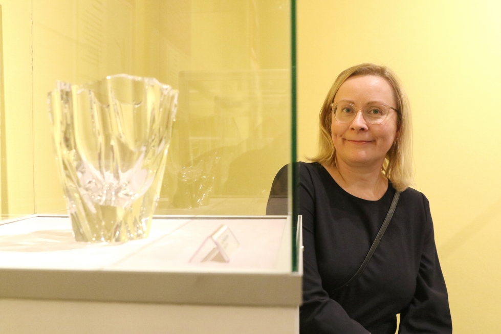 Elina Karila esittelee Tapio Wirkkalan suunnittelemaa Jäävuori-maljakkoa, joka on yksi suomalaisen lasimuotoilun ikonisista esineistä.