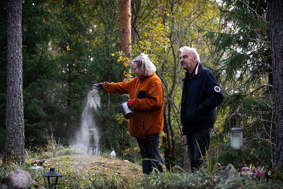 Fanny Hämäläinen sirottelee eläinten tuhkaa Muistojen lehtoon, joka sijaitsee krematorion pihamaan metsikössä. Ilpo Hämäläisellä on 25 vuoden kokemus alalta.