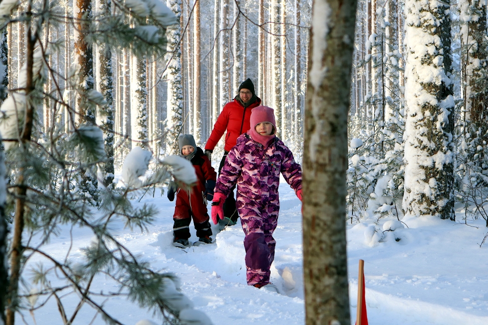 Minea, Eetu ja isä Pasi Metsäpuro kokeilivat lumikenkiä Joensuun Ladun tapahtumassa.