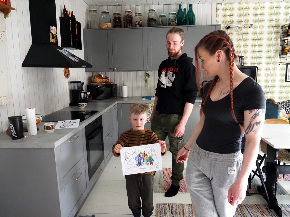 Into esittelee isälleen Niko Kukkoselle ja äidilleen Minna Hautamäelle väritystehtävää, jonka hän teki päivähoidossa.