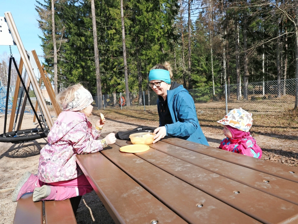Kaisu Leinonen tarjoaa tyttärilleen Varpu (vas.) ja Liisi Turuselle välipalaa leikkikentällä leikkimisen lomassa.