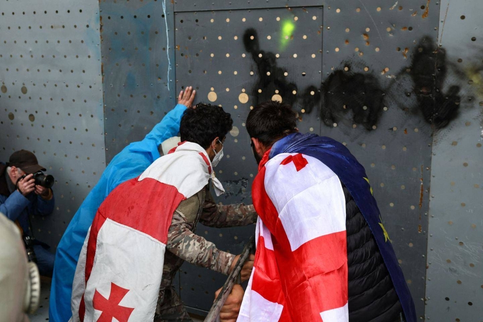Agenttilakia vastustavat mielenosoittajat yrittivät tiistaina rikkoa Georgian parlamenttirakennuksen pääportin eteen asennettua metalliestettä.