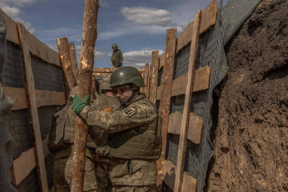 Ukrainalaissotilaat rakentamassa juoksuhautaa Donetskin alueella.