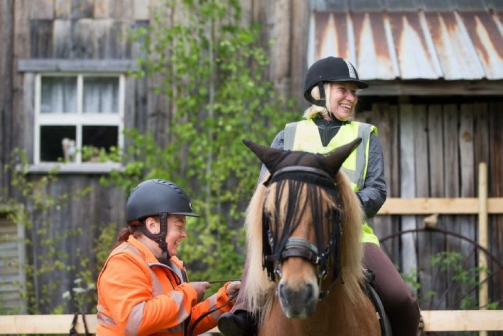Heiskalan Hoppalan hevoset viettävät kesän Karvisen Kissanpäivillä. Minna Vihinen on juuri noussut ratsaille, Helena Heiskanen säätää vielä jalustinhihnoja.