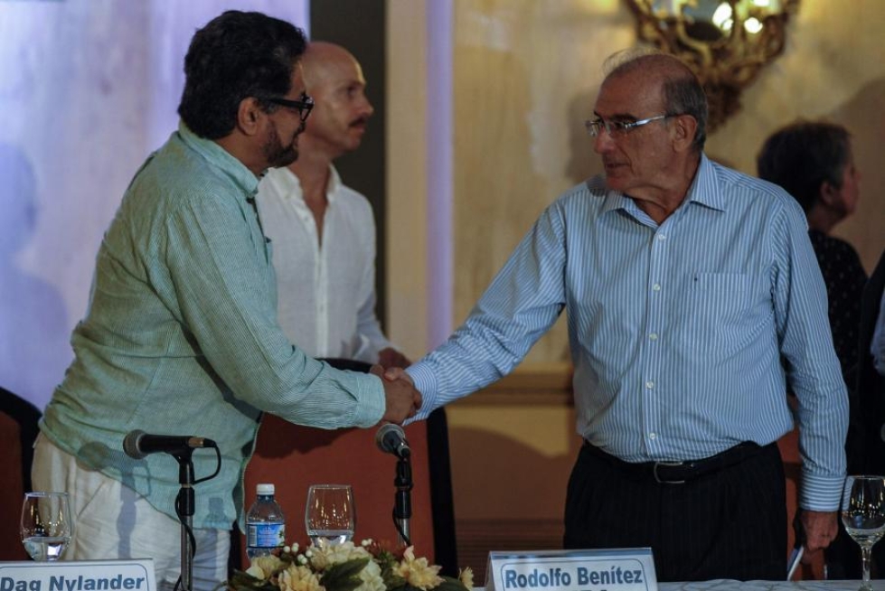 Farcin komentaja Ivan Marquez (vas.) ja Kolumbian valtuuskunnan johtaja Humberto de la Calle kättelivät lehdistötilaisuudessa Kuuban Havannassa. LEHTIKUVA/AFP