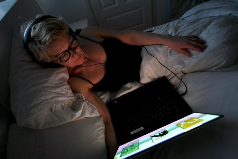 Nainen kuuntelee äänikirjaa internetistä kotonaan. LEHTIKUVA / JUSSI NUKARI