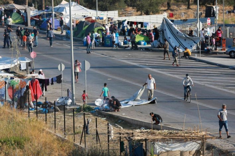 Siirtolaiset keräävät tavaroitaan kaduilla ennen siirtymistä nopeasti kyhättyyn leiriin. Lehtikuva/AFP